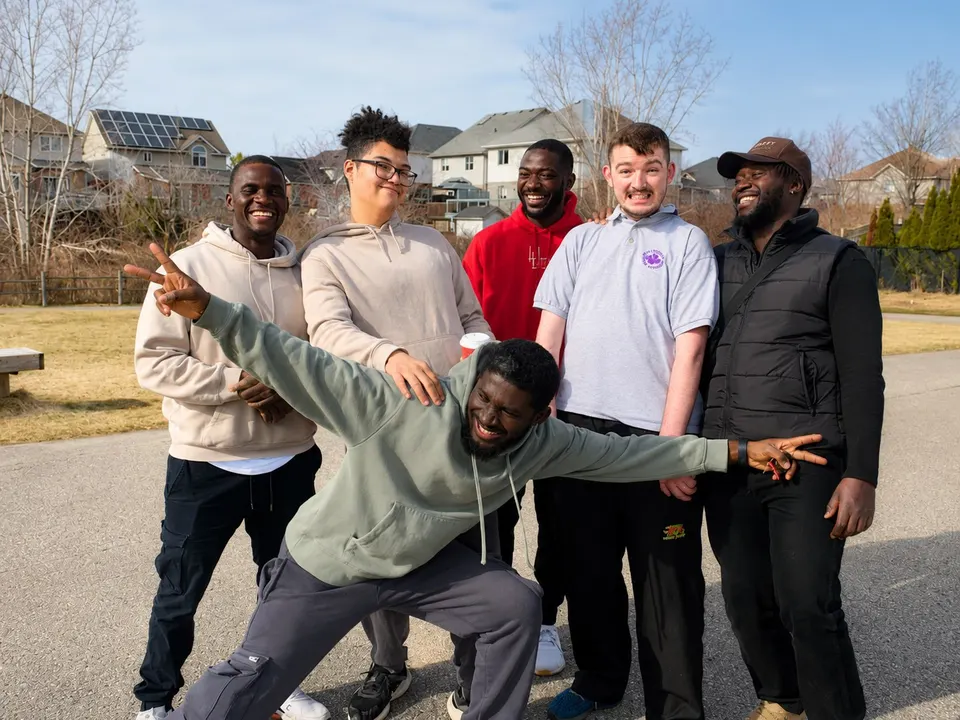 A group of adults and support staff having fun together outdoors at a Hopewell home