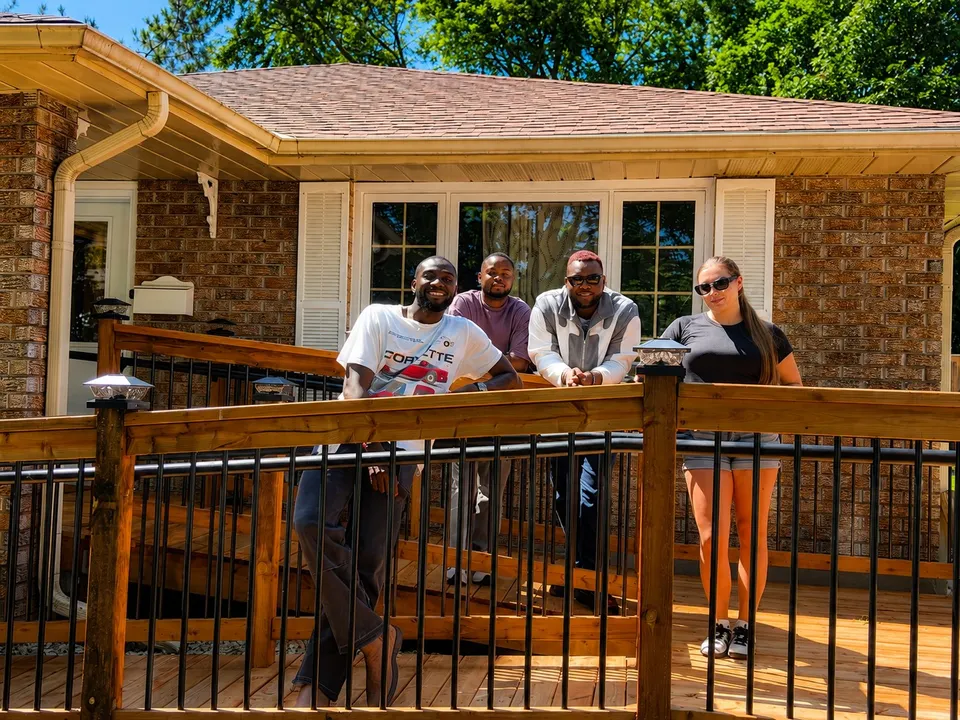 Housemates and support staff gathered on the back deck of the home