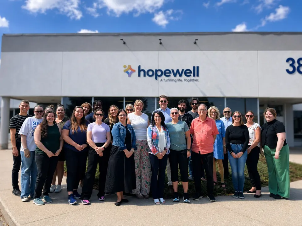 The Hopewell team gathered outside the Guelph office beneath the new Hopewell sign on the day of the name change in 2024