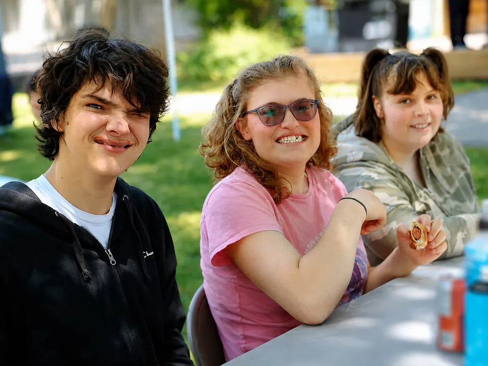 Adults enjoying a meal together outdoors at Ooster House on a summer day