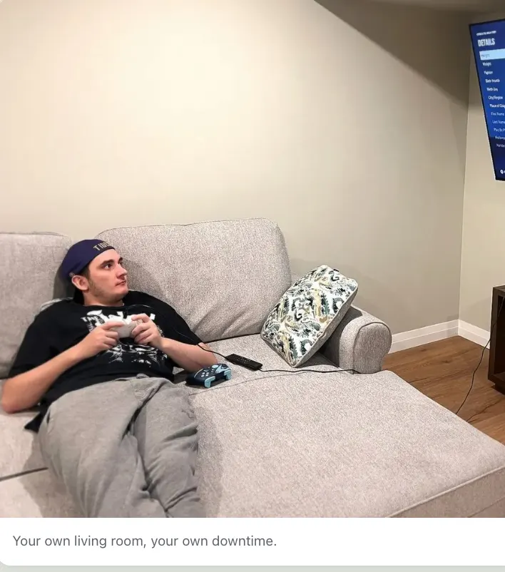 A young man relaxing on the sofa playing a video game in his living room